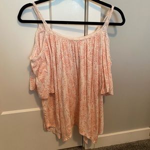 Salmon colored floral shirt with exposed arms.